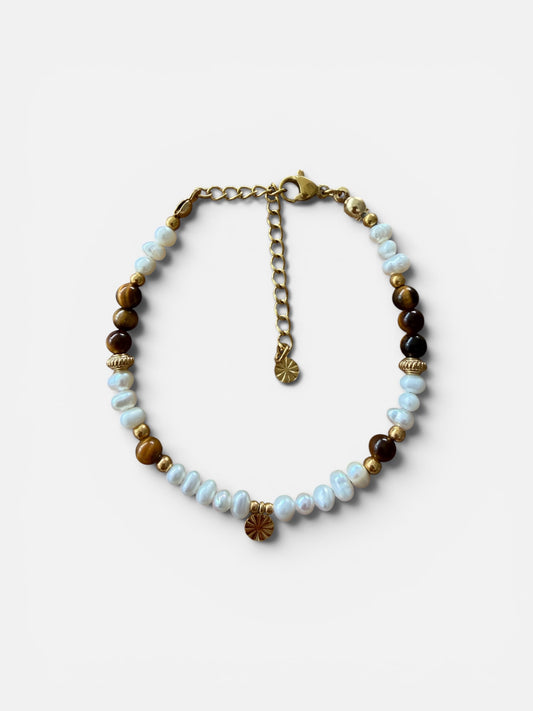 Handgefertigtes Solea Armband aus natürlichen Süsswasserperlen, Tigerauge und vergoldeten Edelstahldetails auf weissem Hintergrund. 