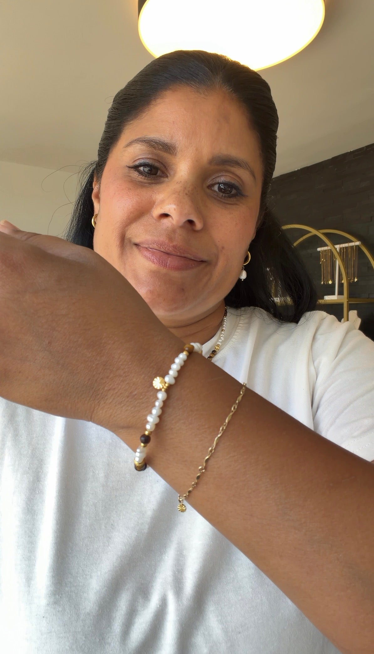 Handgefertigtes Solea Armband aus natürlichen Süsswasserperlen, Tigerauge und vergoldeten Edelstahldetails getragen.