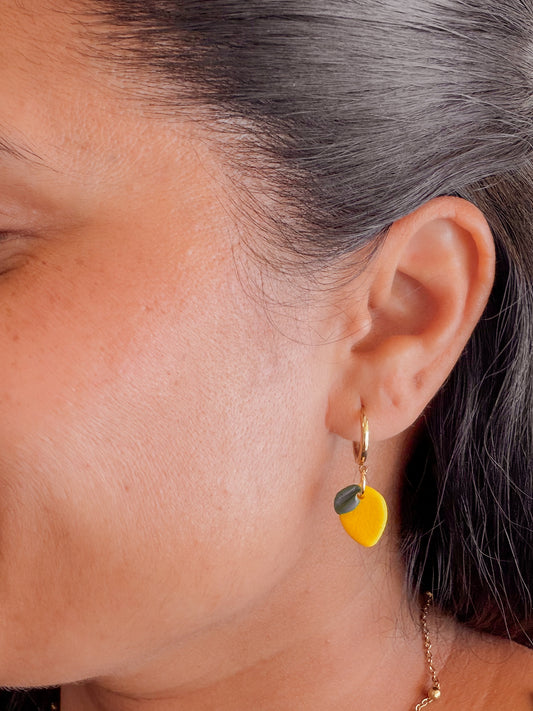 Zitronen Ohrringe aus Polymer Clay an goldener Creole getragen. 